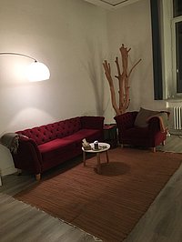 Praxisraum für Therapie in Verden mit Sofa, Teppich, Beistelltisch und dekorativen Elementen.