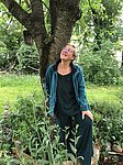 Gina Maier steht vor einem Baum und schaut nach oben